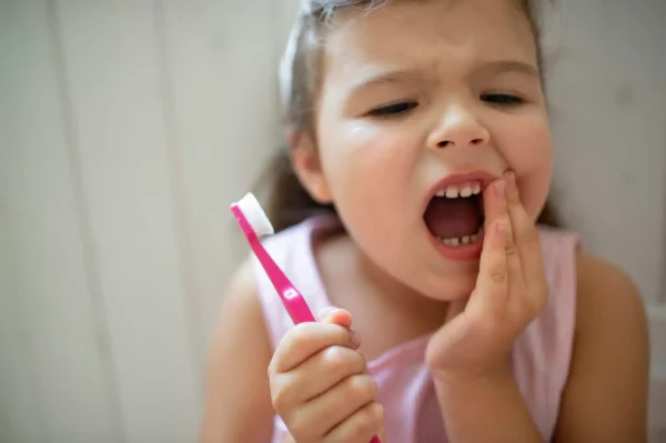 Photographie d'une petite fille souffrant de douleurs aux dents